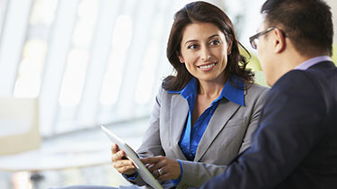 Woman smiling at a man and looking at a mobile device